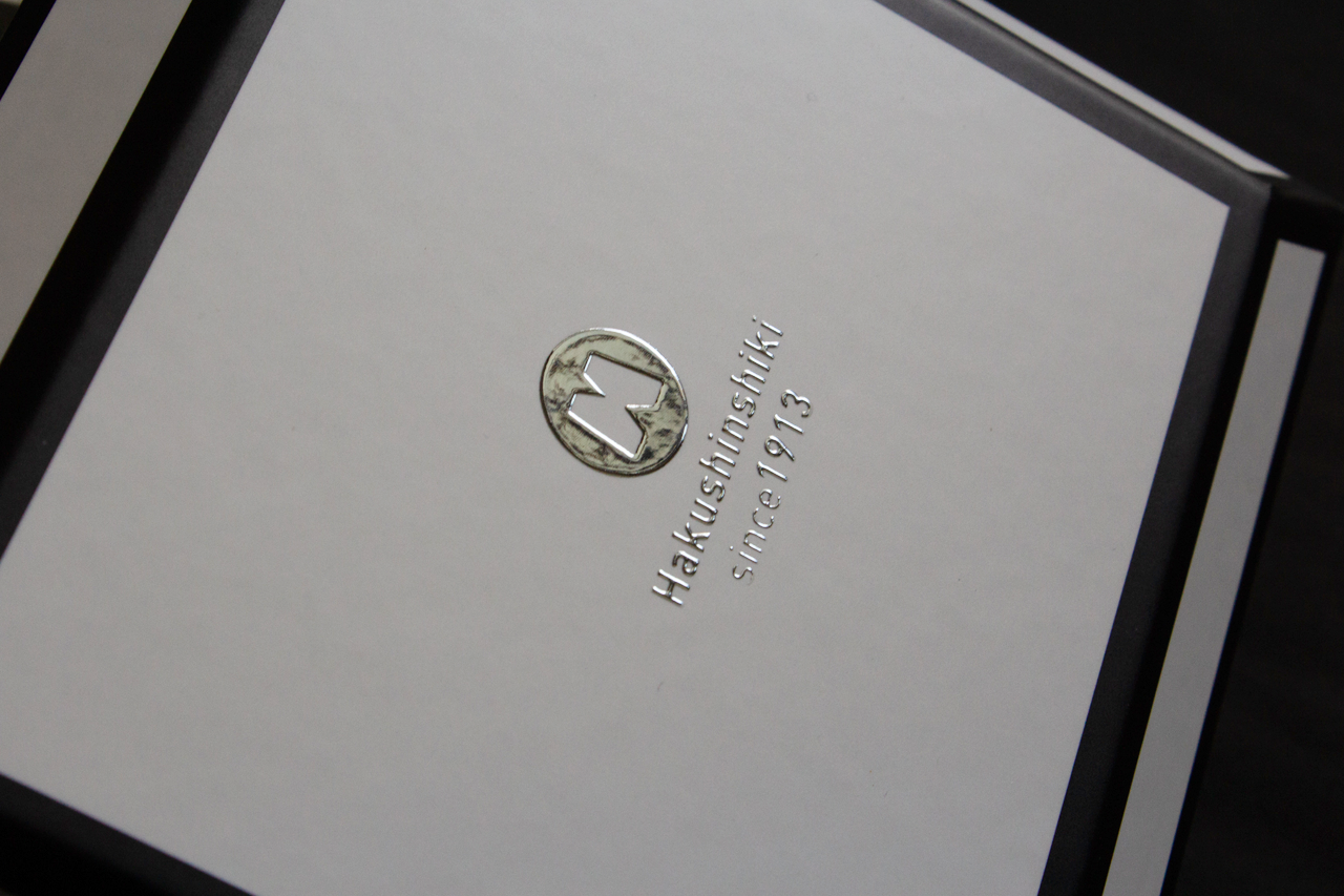ロゴデザインをリキッドメタルを使って、エンボス状の銀箔で表現した貼り箱